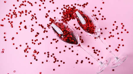 banner two champagne glasses with confetti isolated on an empty pink festive background, copy space,...