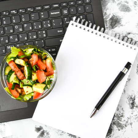 Healthy business lunch snack in office, vegetable salad, empty notebook with pen, copy space, low...