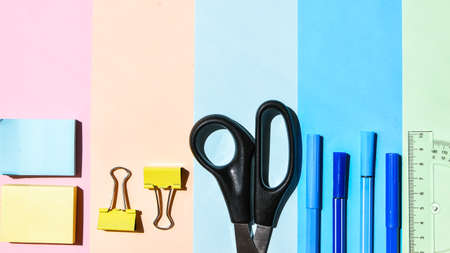School Supplies In Frame With Colorful Paper Background. School or office stationery on colorful...