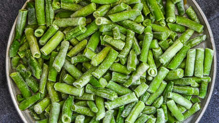 Fresh frozen green beans in a plate. Stocking up vegetables for winter storage. Healthy nutrition....