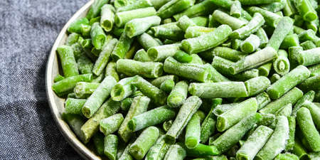 Fresh frozen green beans in a plate. Stocking up vegetables for winter storage. Healthy nutrition. Frozen beans vitaminsの写真素材