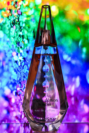 Zhytomyr, Ukraine - June 2, 2020. A clear orange glass spray bottle of Givenchy Ange ou Demon Le secret Parfum for woman on color background, Female perfumeのeditorial素材