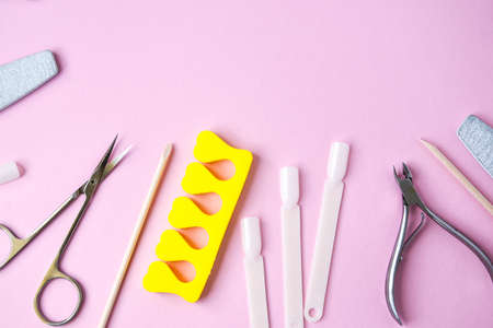 Manicure and pedicure tools on pink background, view from above. Nail salon banner design template. Beauty treatment concept. Copy space for textの写真素材