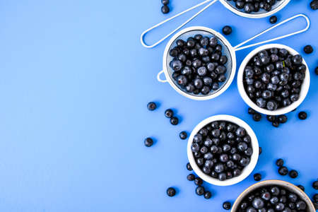 Berries. Blueberry. Forest Berries in a bowl on blue background. Background with selective focus. Copy space. Fresh recently picked blueberriesの写真素材