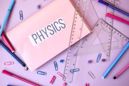 school book. physics with supplies stationery on color background, back to school, ruler, pencilsの写真素材