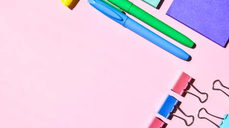 Different office or school supplies on pink background. Copy space for text, pencil paper clip...