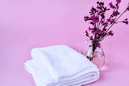 Clean and fresh white cotton towels, Spa treatment with blooming branch on pink background, copy space, spa decorationの写真素材