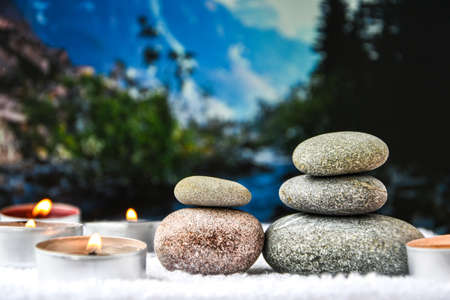 Zen concept, spa pebbles stones and burning aroma candles on blurred background, Treatment aromatherapy and massage, copy space for textの写真素材
