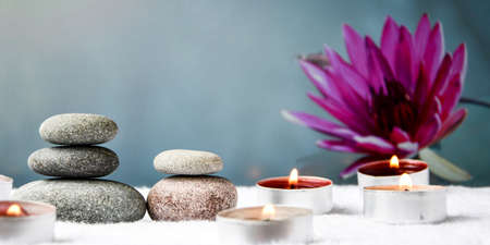 Zen concept, spa pebbles stones and burning aroma candles on blurred background, Treatment aromatherapy and massage, copy space for textの写真素材
