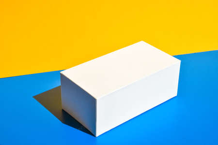 White box. Drugs box mock-up. Mockup. Copy space. Yellow and blue creative minimalism isometric background. Hard light. Shadowsの写真素材