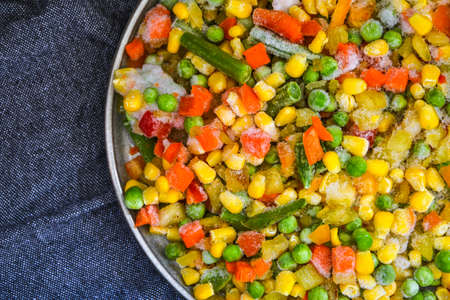 Mixed frozen vegetables in a plate. Stocking up vegetables for winter storage. Assortment of frozen...