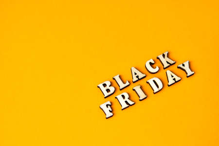Wooden letters text BLACK FRIDAY in front yellow background, copy space, banner Top view Flat lay seasonal sale, retail, shopping concept. Black friday saleの写真素材