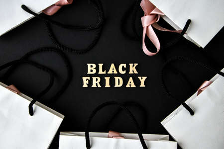 Wooden letters text BLACK FRIDAY with packaging bags in front black background, copy space, banner Top view Flat lay seasonal sale, retail, shopping concept. Black friday saleの写真素材