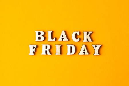 Wooden letters text BLACK FRIDAY in front yellow background, copy space, banner Top view Flat lay seasonal sale, retail, shopping concept. Black friday saleの写真素材