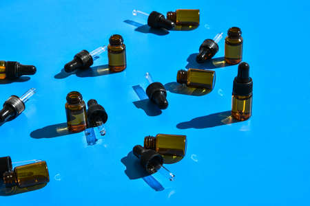 Bottles of essential oils on color background, flat lay. Cosmetic products. Dropper. Brown cosmetic and essential oil bottles, aromatherapy, natural cosmetics, phytotherapy, concept.の写真素材