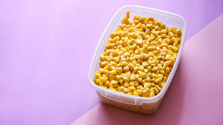 Corn in a plastic container for long-term storage. Deep freezing of vegetables. Frozen food...
