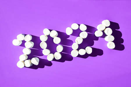 Marshmallows 2021 on blue background close up and copy space. New Year 2021 made of marshmallows. Winter food background concept.の写真素材