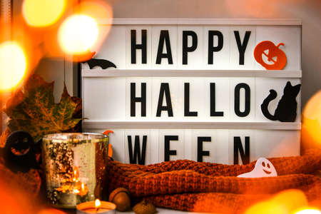 HAPPY HALLOWEEN. Text in white light box, with a background of sweater, dried leaves halloween...