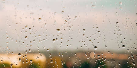 Drops of rain on the window. Rainy days in the city landscape. Defocusedの写真素材