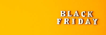 Wooden letters text BLACK FRIDAY in front yellow background, copy space, banner Top view Flat lay seasonal sale, retail, shopping concept. Black friday saleの写真素材