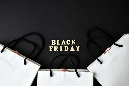 Wooden letters text BLACK FRIDAY with packaging bags in front black background, copy space, banner Top view Flat lay seasonal sale, retail, shopping concept. Black friday saleの写真素材