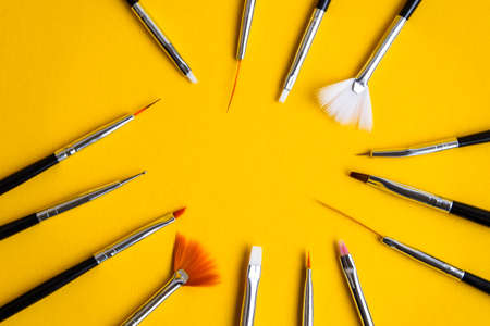 black brushes for nail design on yellow background, Manicure tools brushes for drawing on nails,...