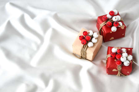 Zero waste Christmas presents with decorations on champagne colored silk background. Copy space. Eco friendly packed gift with tags from craft cardboard. New yearの写真素材