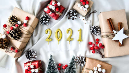 2021 candles Zero waste Christmas text with presents with decorations on champagne colored silk...