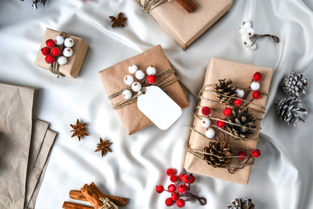 Zero waste Christmas presents with decorations on champagne colored silk background. Copy space. Eco...