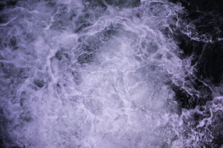 Beautiful foamy sea. Water flowing from the open sluice gates of dam. The blue sea water with spray. The texture of the wavesの写真素材