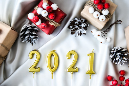 2021 candles Zero waste Christmas text with presents with decorations on champagne colored silk background. Copy space. Eco friendly packed gift with tags from craft cardboard. New yearの写真素材