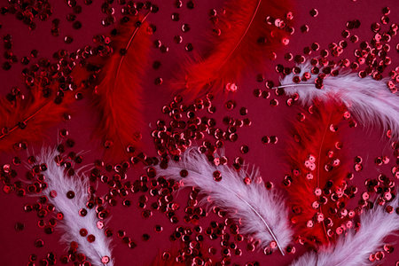 Red shiny confetti sequinned background with feathers. Saint Valentines Day and Christmas background. Holidays background and textures.の写真素材