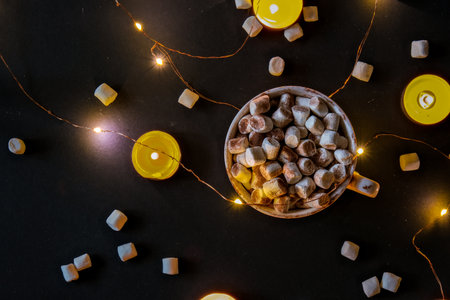Cup with hot winter cacao and marshmallows at night. Christmas lights. Tea light candles. Good night sweet dreams. Cozy winter days. Hygge.の写真素材