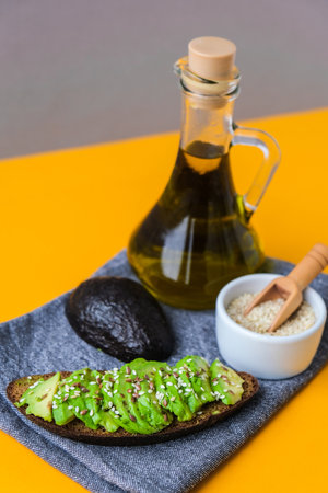 Ingredients for healthy avocado toast. ripe hass avocado, wholegrain bread, sesame flax seeds oil....