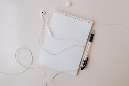 Open blank notebook with headphones and black pen. Copy space foe text. Top view. Pastel colorsの写真素材