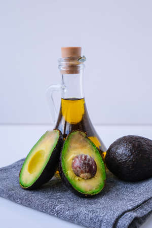Pitcher of natural oil and fresh ripe hass avocados. Preparing food in the kitchen. Ingredients. Concept of healthy food. Healthy eating. Keto dietの写真素材