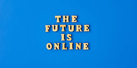 The future is online text with mobile phone. Technologies on workplace. The future is online lettering. Online education, work from home. Headphones and coffeeの写真素材