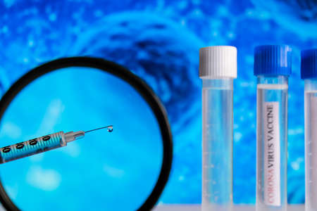 Syringe with Ampoules Covid-19 vaccine on a laboratory bench. Fight the coronavirus, sars-cov-2...