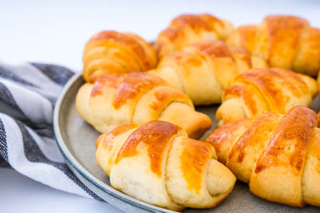 Homemade delicious croissants on a dessert gray plate on kitchen towel. Tasty homemade buttery croissants cake. Home bakery.の写真素材