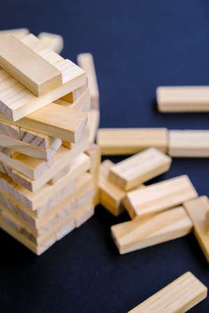 Building from wooden blocks . Wood blocks stack game with Hand on background. Conceptual of...