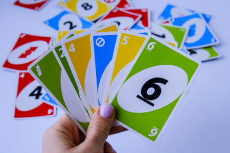 Kiev, Ukraine - 10.03.2021 Playing cards UNO in female hand. Table games. Pastime. Board games. Stay home leisure activity for kids.のeditorial素材