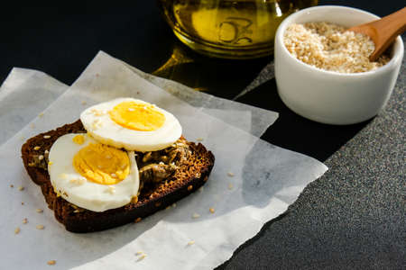 Toasted breads with boiled egg and avocado. Guacamole sandwiches. Healthy breakfast. Olive oil. Sesame seeds. Vegetarian healthy eating. Diet. Snack Selective focus, close upの写真素材