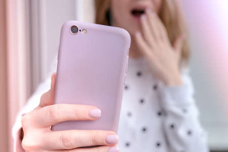 Blonde young girl taking selfie. Video call. Online education. Work from home. Woman holding smartphone. Phone call. Recording new vlog for her channel. Blogger Conference surprisedの写真素材