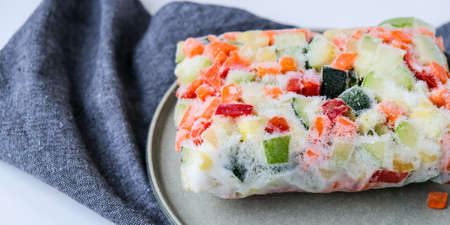 Frozen mixed vegetables in plate for long-term storage. Deep freezing of vegetables. Veganism, vegan food preparing for winter. Harvestの写真素材