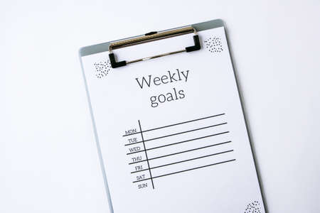 Weekly goals planner on white background. Planning week to stay productive when working from home during quarantine period. Flat lay. Top view.の写真素材