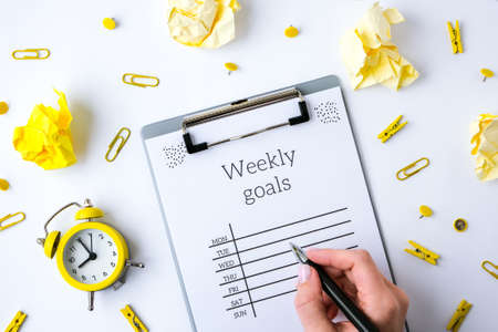 Weekly goals planner on white background. Planning week to stay productive when working from home during quarantine period. Flat lay. Top view.の写真素材