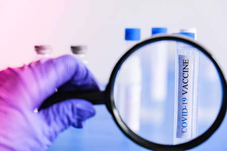 Ampoules Covid-19 vaccine on a laboratory bench. Fight the coronavirus, sars-cov-2 pandemic. Coronavirus 2019-nCoV COVID concept.の写真素材
