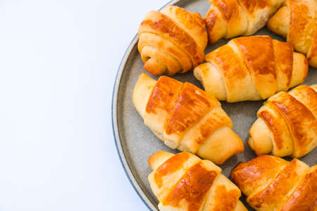 Homemade delicious croissants on a dessert gray plate. Tasty homemade buttery croissants cake. Home bakery. Frances national food. Morning breakfastの写真素材