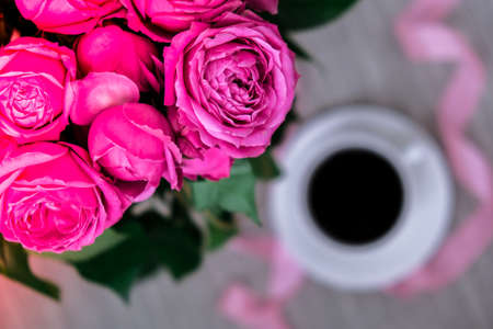 Cup of coffee and pink roses. Holiday concept, bouquet of roses for a birthday, bouquet of flowers...