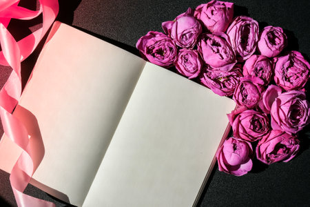 Holiday mock up, pink roses with notebook for birthday, valentines mothers womans day, bouquet of flowers in the morning. Selective focus. Peonies Flat lay. Top view. Copy spaceの写真素材